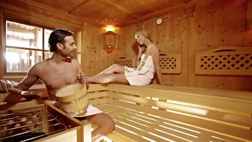 Ein Paar sitzt in einer Sauna und relaxt 