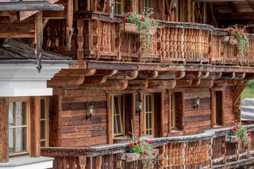 Balkon aus Altholz mit roten Balkonblumen